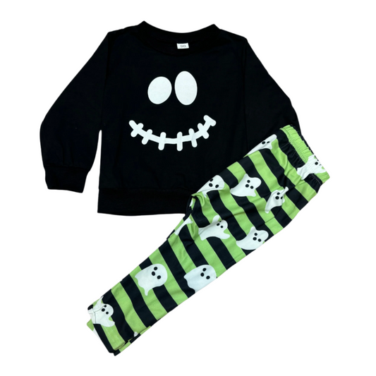 A black long sleeve shirt with a spooky face print and green and black striped pant with fun ghost prints, presented as a Halloween costume set.